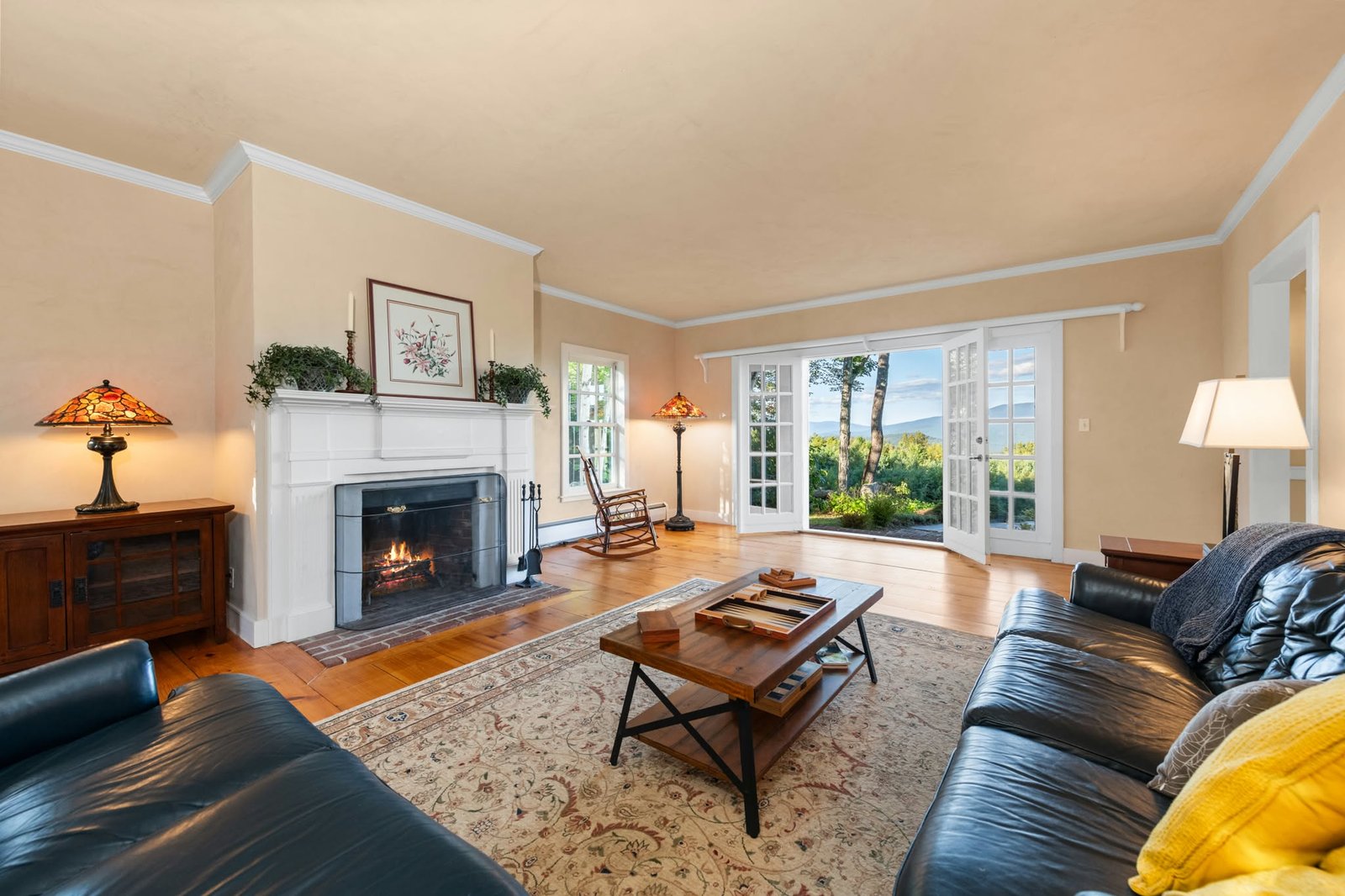 Living room with a fireplace and French doors overlooking the mountains