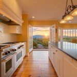 Kitchen with a dark island and open doors overlooking the mountains